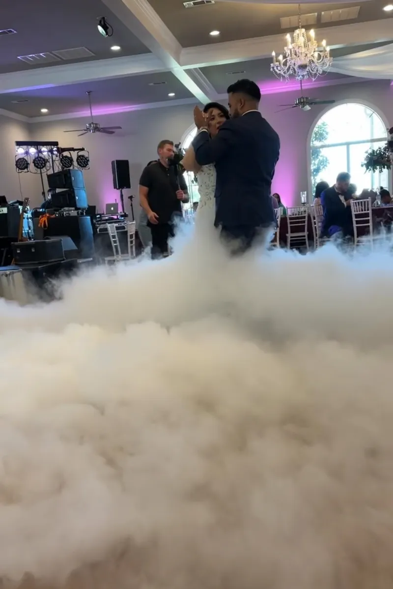 Bride and groom share a Dance on the Clouds first dance moment on a fog-covered dance floor at a DJ Oso wedding reception